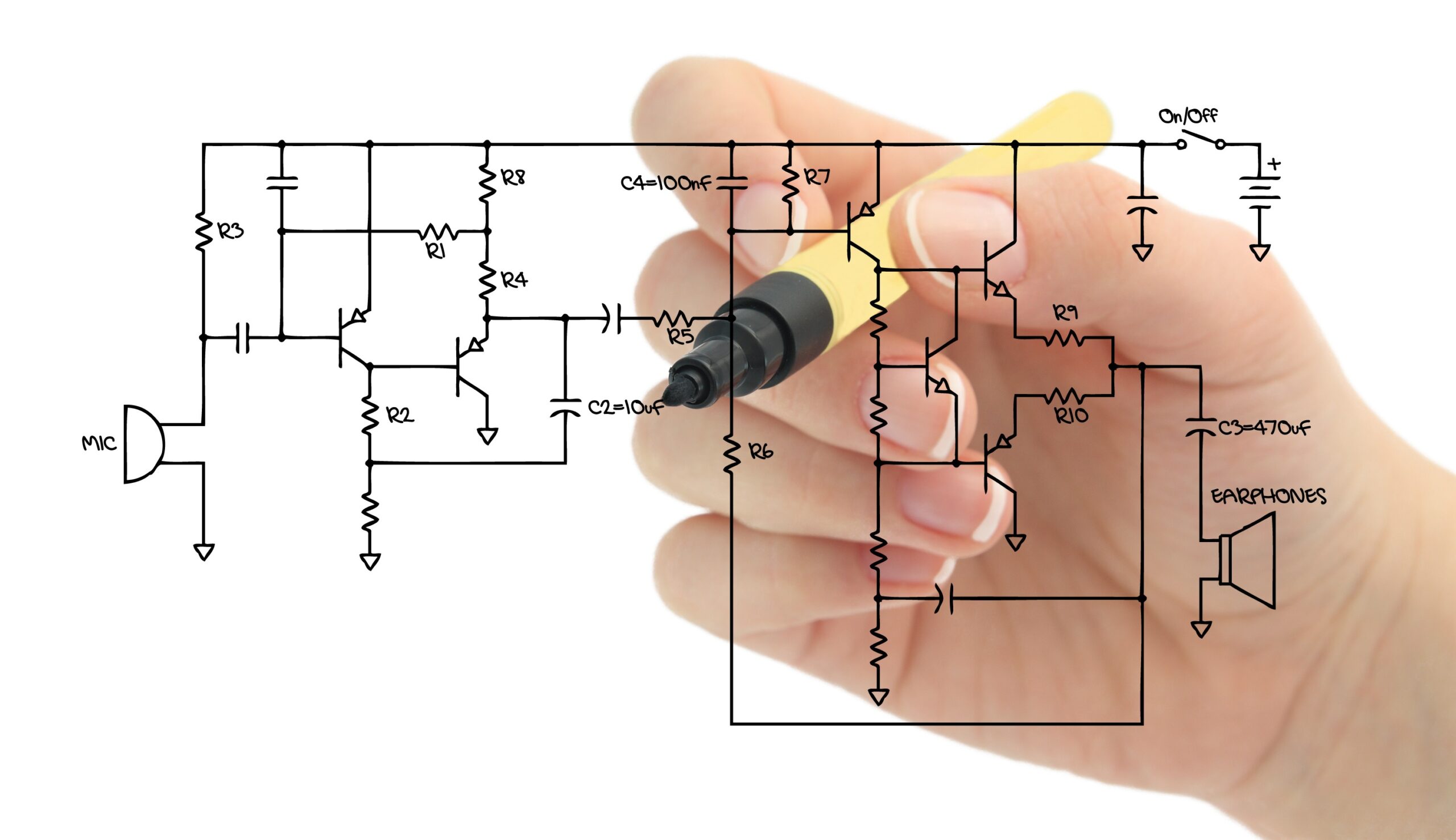 A hand grasping a marker used to draw a circuit schematic.