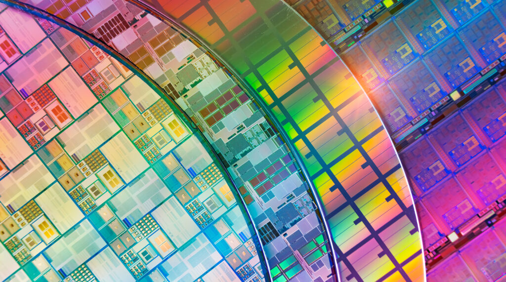 Whole wafers showing custom microchips on surface.