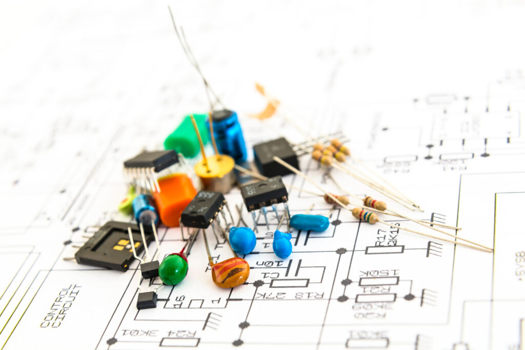 A small pile of electrical components placed on a circuit schematic.